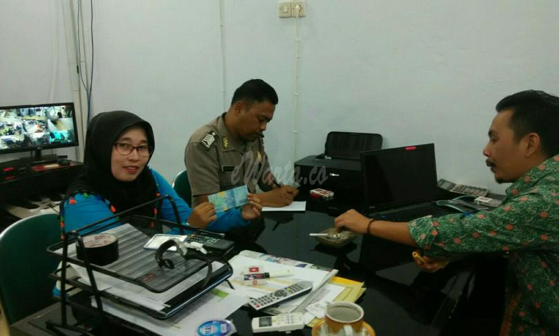 Polisi dan karyawan Bank serta Septi Meriani mengecek uang pecahan 50.000 yang di duga palsu