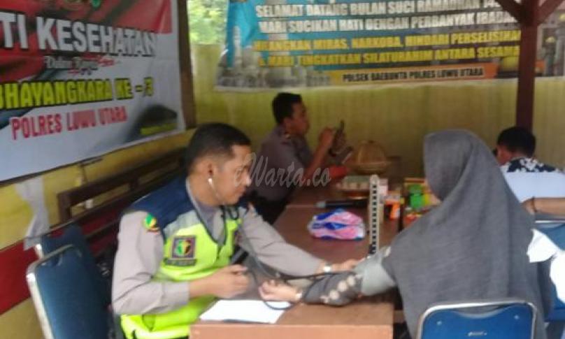 Petugas media dari tim dokkes Polres Lutra sedang mengecek kesehatan warga
