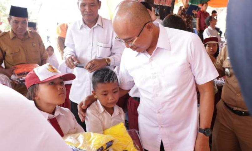 Bupati Bengkulu Selatan, Gusnan Mulyadi menyerahkan bantuan seragam sekolah
