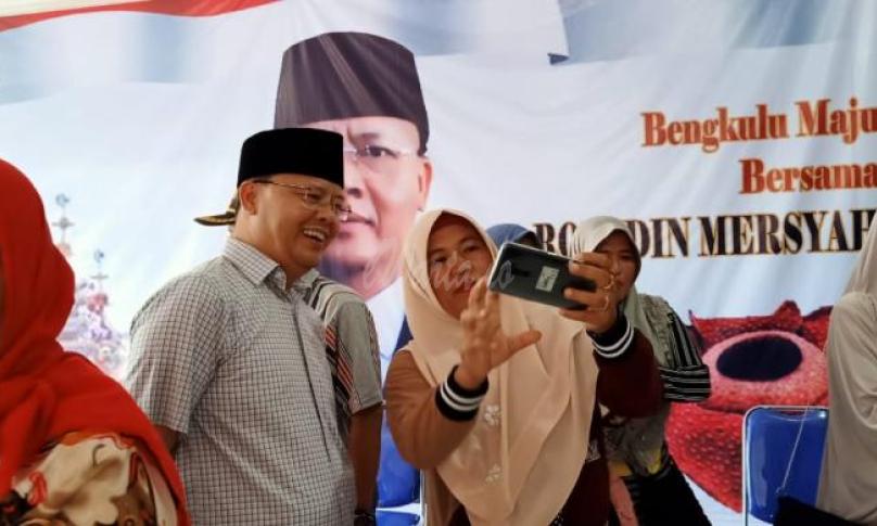 Terlihat salah satu warga mengajak berselfi dengan Gubernur Bengkulu, Rohidin Mersyah.