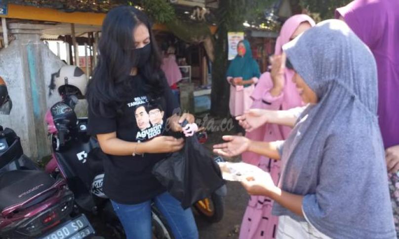 Relawan Agusrin - Izda Putra membagikan masker dan vitamin ke warga.