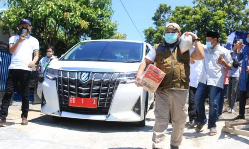 Helmi memikul beras 5 KG dan menenteng 1 dus mie instan terenak di dunia. Helmi langsung menyapanya dengan ramah.