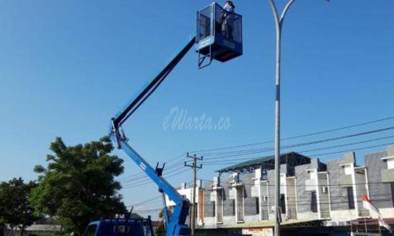 Petugas Dishub sedang lakukan perbaikan lampu jalan.