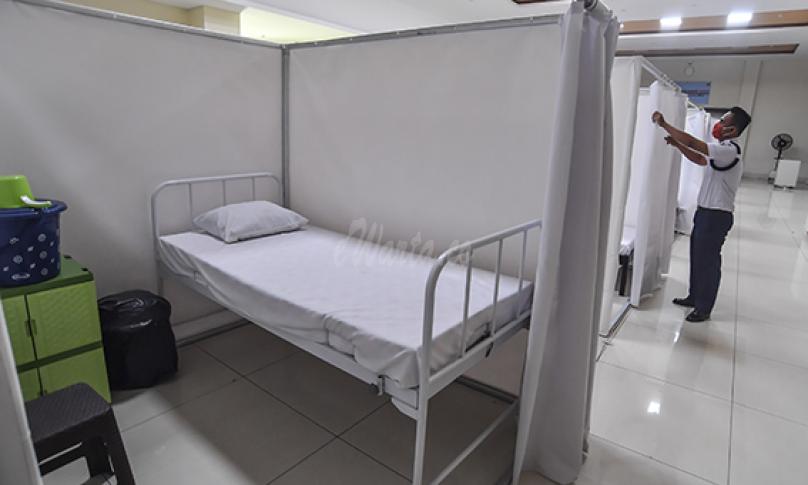 Petugas merapikan ruang isolasi mandiri pasien Covid-19 di Gelanggang Remaja Kecamatan Pademangan, Jakarta, Minggu (27/9/2020). (antarafoto)