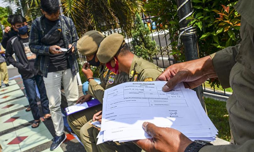 Petugas Satpol PP dan Polisi mendata pengendara yang tidak menggunakan masker saat Operasi Yustisi Penegakan Disiplin Protokol Kesehatan di Jalan Jendral Sudirman, Kabupaten Ciamis, Jawa Barat, Selasa (15/9/2020). (antarafoto)