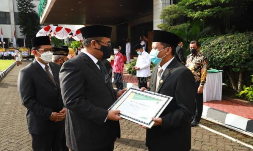 Menteri Agama Yaqut Cholil Qoumas menyerahkan penghargaan kepada Budi Ali Hidayat, penghulu madya yang juga Kepala KUA Cimahi Tengah atas keteladanann