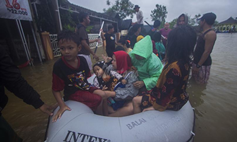 Sejumlah relawan menggunakan perahu karet membantu evakuasi warga yang terdampak banjir di Desa Kampung Melayu, Kabupaten Banjar, Kalimantan Selatan, Jumat (15/1/2021). - (antarafoto)