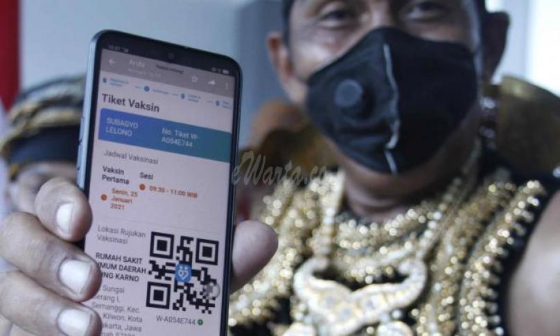 Penerima vaksin berkostum wayang Partika Subayo Lelono menunjukkan tiket elektronik penerima vaksin COVID-19 produksi Sinovac di Rumah Sakit Umum Daerah (RSUD) Bung Karno, Solo, Jawa Tengah, Jumat (22/1/2021). - (antarafoto)