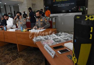  Kadiv Humas Polri Irjen Pol Argo Yuwono (kedua kiri) didampingi Karopenmas Div Humas Polri Brigjen Pol Awi Setiyono (ketiga kiri) dan Direktur Tindak Pidana Siber (Dirtipidsiber) Bareskrim Polri Brigjen Pol Slamet Uliandi (kiri) menunjukkan tersangka berikut barang bukti saat rilis pengungkapan kasus peretasan situs lembaga negara di Gedung Bareskrim Polri, Jakarta, Selasa (7/7/2020). 