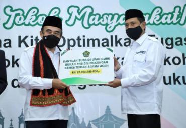 Menag menyerahkan bantuan secara simbolis kepada Kakanwil Kemenag Aceh (Foto: Rikie)