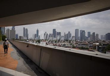 Warga mengenakan masker dan pelindung wajah saat beraktivitas dengan latar belakang gedung bertingkat di kawasan Pejompongan, Jakarta, Rabu (25/11/2020). Lembaga konsultan Centre of Reform on Economics (Core) menilai pemulihan ekonomi Indonesia pada 2021 akan bergantung pada tingkat konsumsi masyarakat kelas menengah ke atas karena golongan tersebut memiliki daya beli yang terjaga di tengah pandemi Covid-19. - (antarafoto)