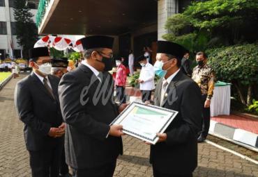 Menteri Agama Yaqut Cholil Qoumas menyerahkan penghargaan kepada Budi Ali Hidayat, penghulu madya yang juga Kepala KUA Cimahi Tengah atas keteladanann
