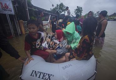 Sejumlah relawan menggunakan perahu karet membantu evakuasi warga yang terdampak banjir di Desa Kampung Melayu, Kabupaten Banjar, Kalimantan Selatan, Jumat (15/1/2021). - (antarafoto)